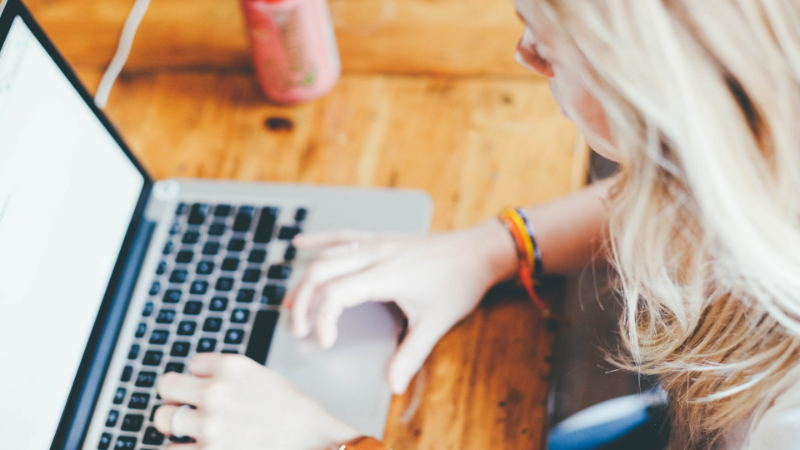 A Woman writing on a laptop.